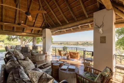 A thatched, open-sided lounge at Buhala Lodge looking across the Crocodile River to the grassland beyond