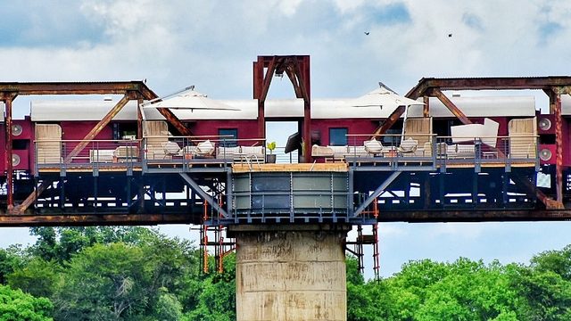 Kruger Shalati, the converted burgundy train carriages standing on the steel railway bridge, sun loungers and umbrellas along their deck